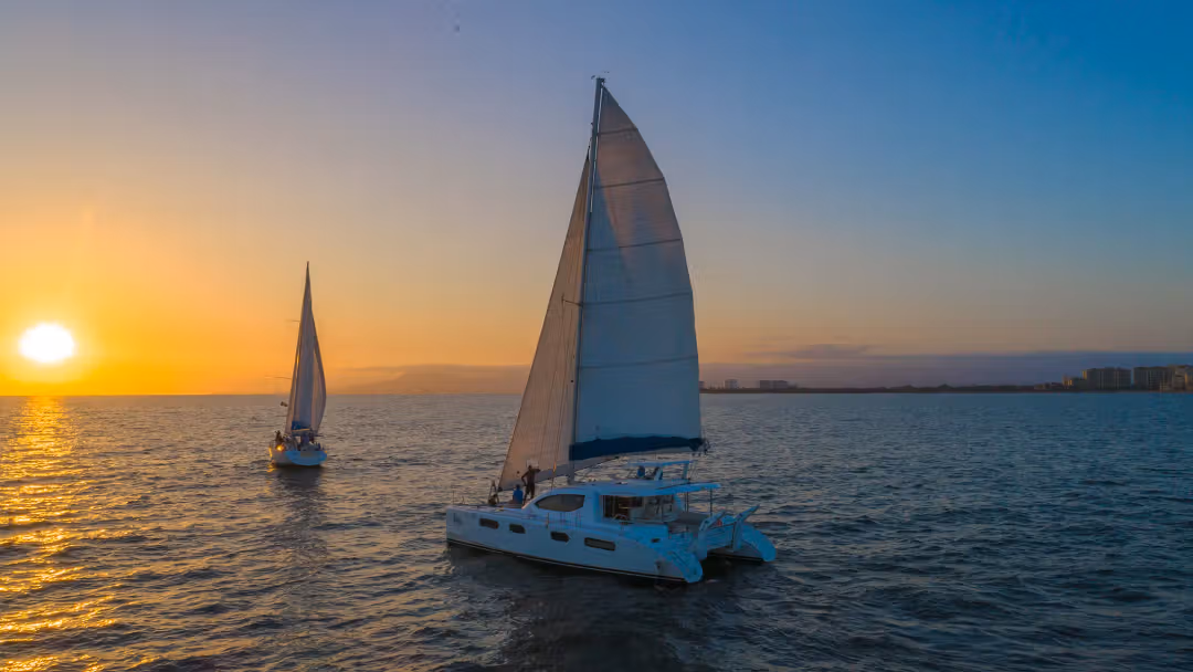 Vibrant sunset reflecting on the ocean with a boat silhouette in the distance