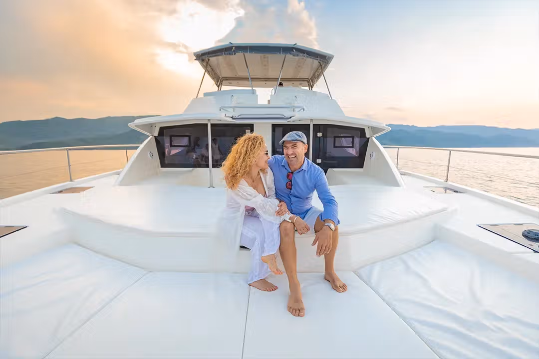 Family laughing together on a catamaran deck during daytime sail