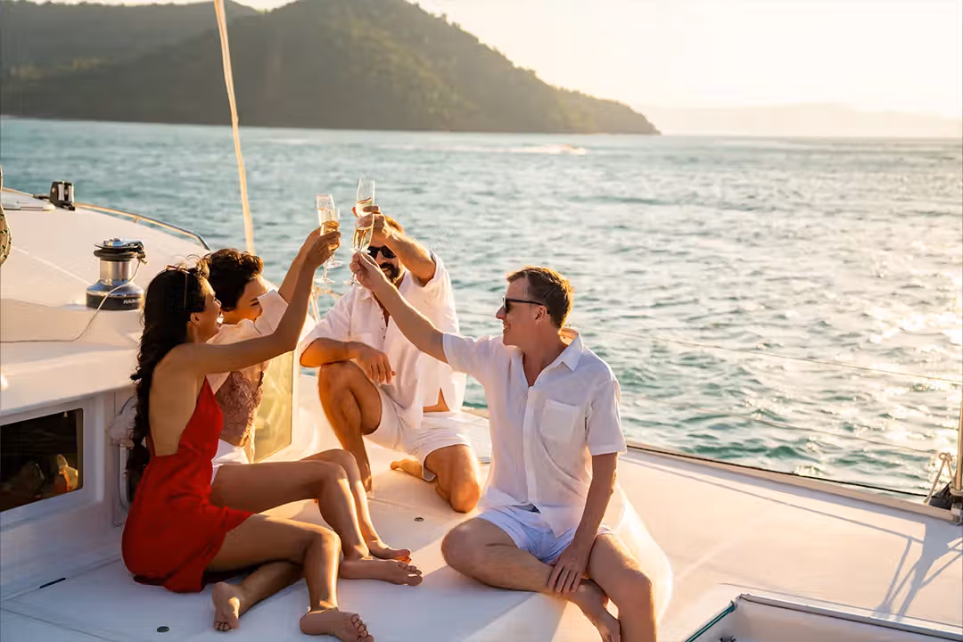 Couple toasting champagne as the sun sets over the ocean